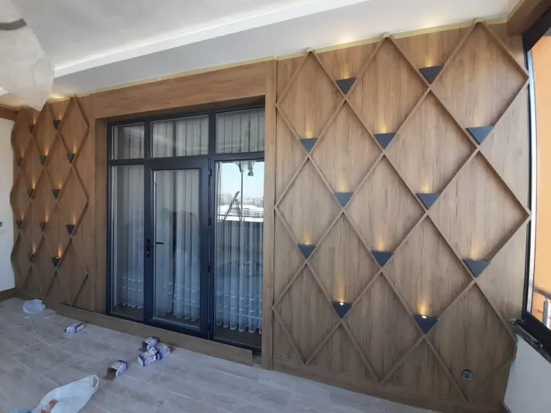 Koridor tasarım detayları: geometrik ahşap duvar paneli ve LED aplik